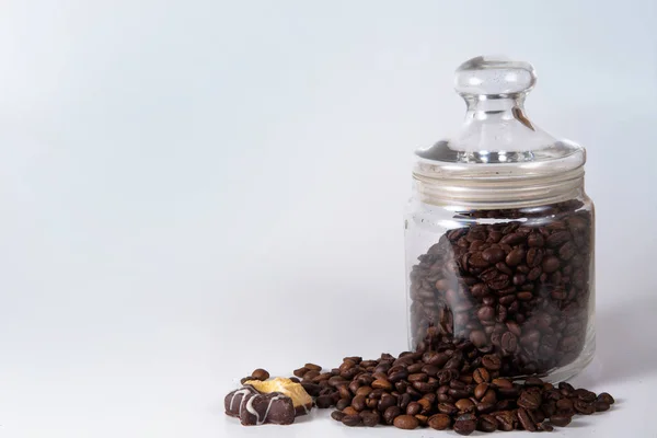 Granos de café en un frasco en la vieja mesa de la cocina . — Foto de Stock