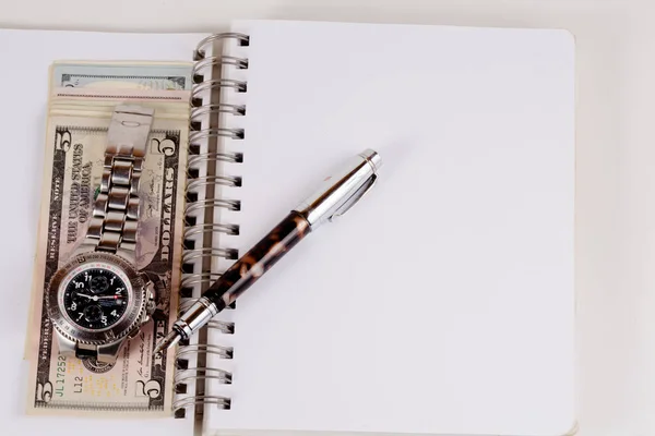 Reloj clásico con un dólar, modelo en billetes de dólar y bolígrafo, notebook —  Fotos de Stock