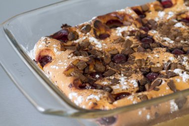 Kek kiraz ve çikolata gri mutfak masasında.