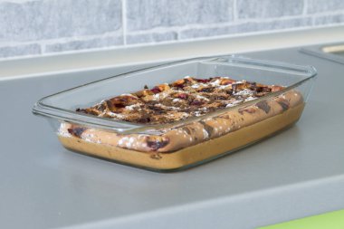 Kek kiraz ve çikolata gri mutfak masasında.