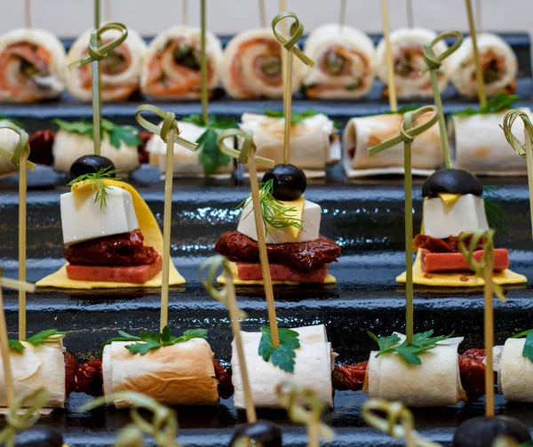 Placa com vários frutos do mar e canapés de carne. Arenque em conserva com ovo, queijo e cereja, salmão, camarão com pepino e salame recheado — Fotografia de Stock