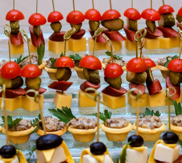 Placa com vários frutos do mar e canapés de carne. Arenque em conserva com ovo, queijo e cereja, salmão, camarão com pepino e salame recheado — Fotografia de Stock