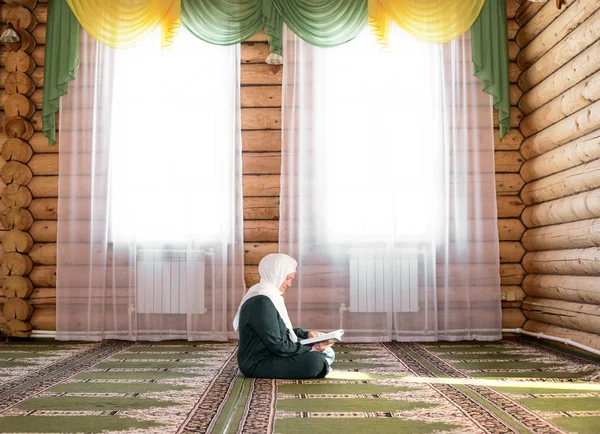 Mulher idosa orando na mesquita e lendo o Alcorão — Fotografia de Stock