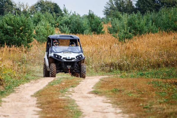 Young people on quad bikes on a countryside trail.