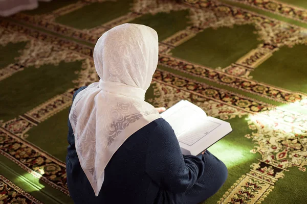 Elderly woman praying in the mosque and reading the Quran — Stock Photo, Image