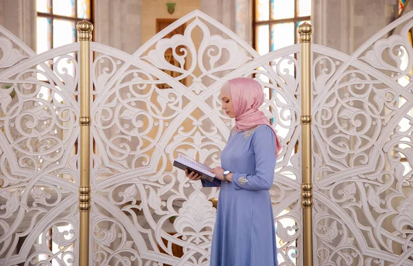 woman praying in the mosque and reading the Quran