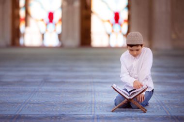 little boy in the mosque read the Quran clipart