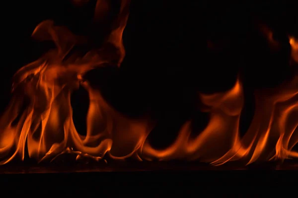 Schöne Feuerflammen auf schwarzem Hintergrund. — Stockfoto