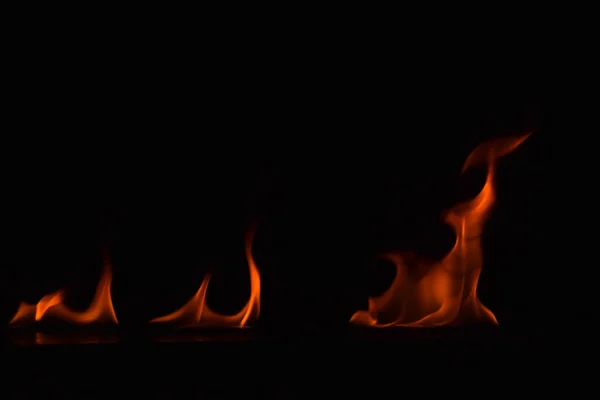 Schöne Feuerflammen auf schwarzem Hintergrund. — Stockfoto