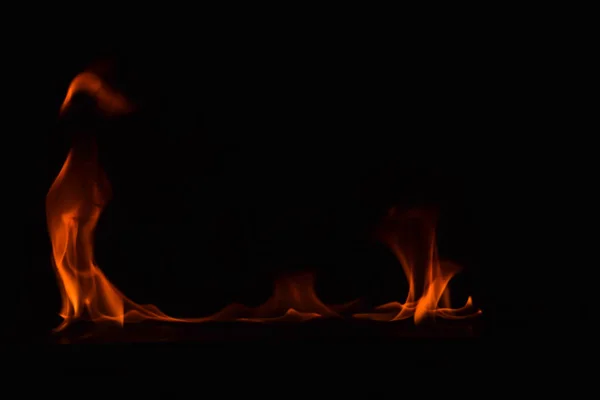 Hermosas llamas de fuego sobre fondo negro . — Foto de Stock