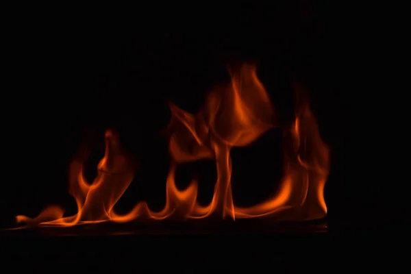 Schöne Feuerflammen auf schwarzem Hintergrund. — Stockfoto