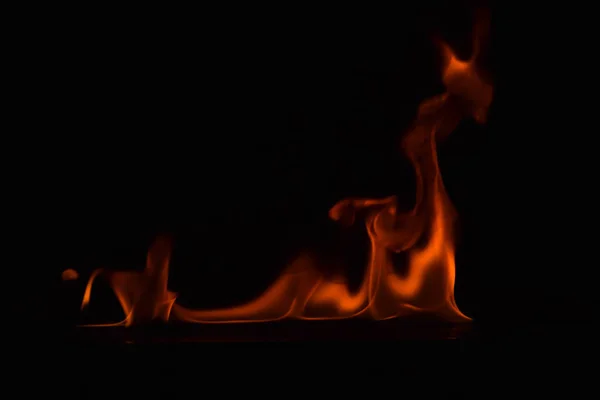 Schöne Feuerflammen auf schwarzem Hintergrund. — Stockfoto