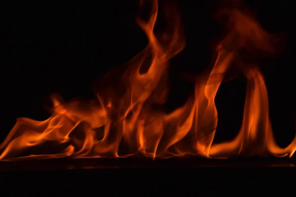 Gyönyörű tűz lángjai fekete háttér. — Stock Fotó