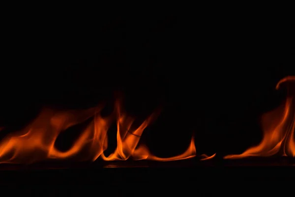 Огонь полыхает на черном фоне . — стоковое фото