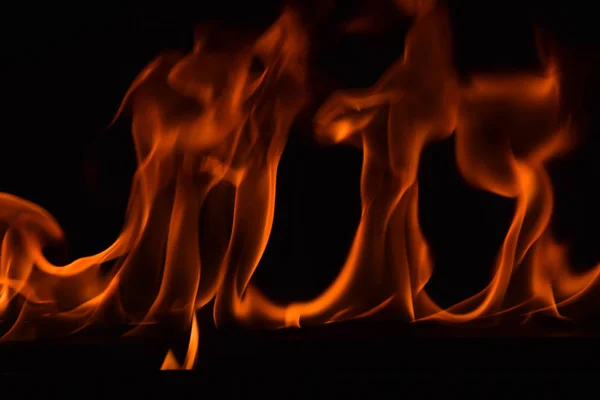 Schöne Feuerflammen auf schwarzem Hintergrund. — Stockfoto