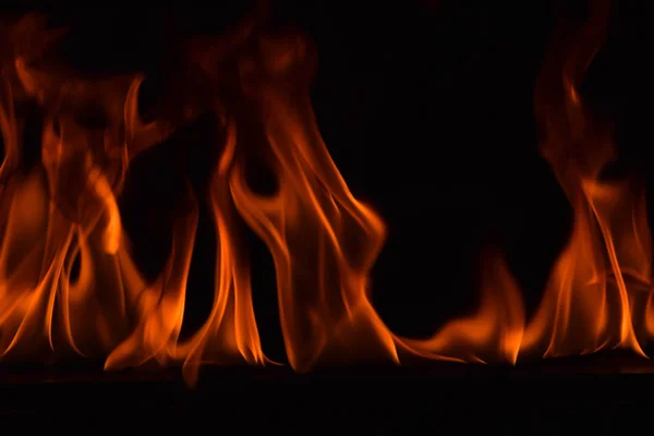 Schöne Feuerflammen auf schwarzem Hintergrund. — Stockfoto