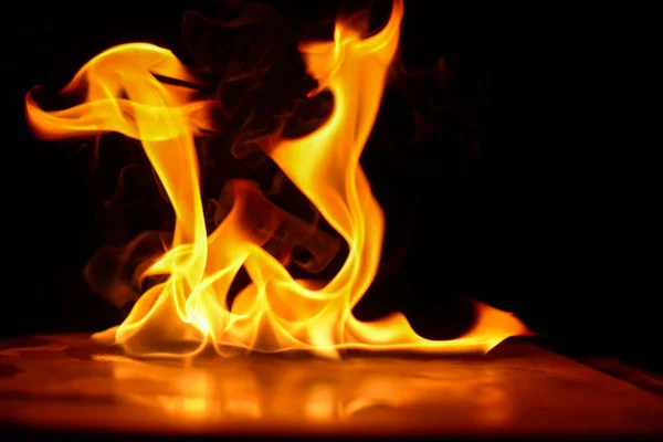 Piękny ogień płomienie na czarnym tle. Zdjęcie Stockowe