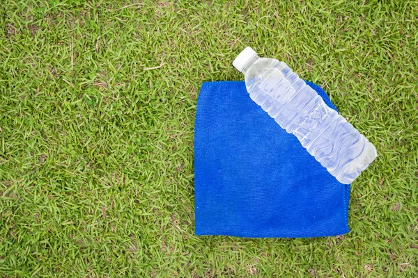 Parte superior - ver botella de agua y toalla con fondo de hierba — Foto de Stock