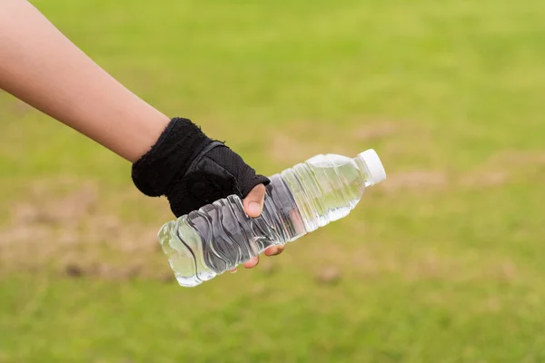 Mano de mujer sana con guantes Sostener la botella de agua dulce — Foto de Stock