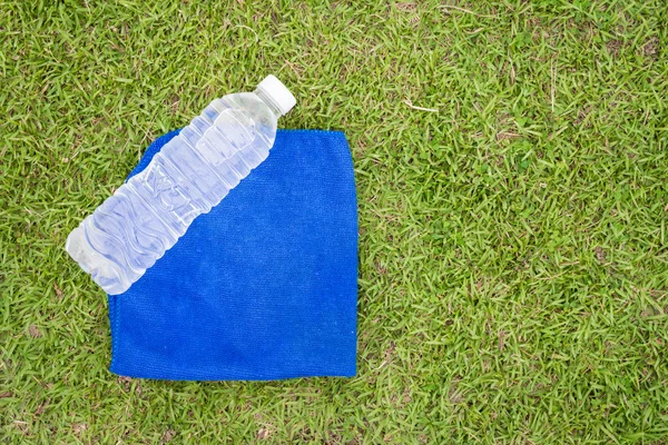 Parte superior - ver botella de agua y toalla con fondo de hierba — Foto de Stock