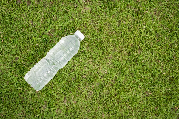 Oben - Ansicht Wasserflasche und Handtuch mit Gras Hintergrund — Stockfoto