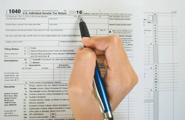 Visão superior da caneta de mão preencher os detalhes sobre os formulários fiscais p — Fotografia de Stock