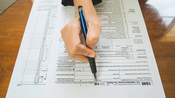 Mujer de negocios mano mantenga la pluma rellene los detalles en el formulario de impuestos — Foto de Stock