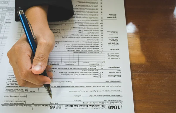 Mujer de negocios mano mantenga la pluma rellene los detalles en el formulario de impuestos —  Fotos de Stock