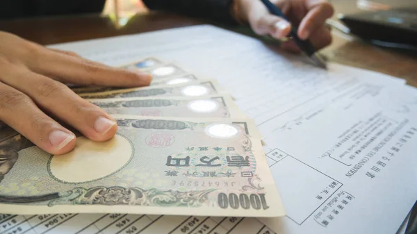 Mujer mano mantenga pluma rellenar los detalles en los formularios de impuestos papel w — Foto de Stock