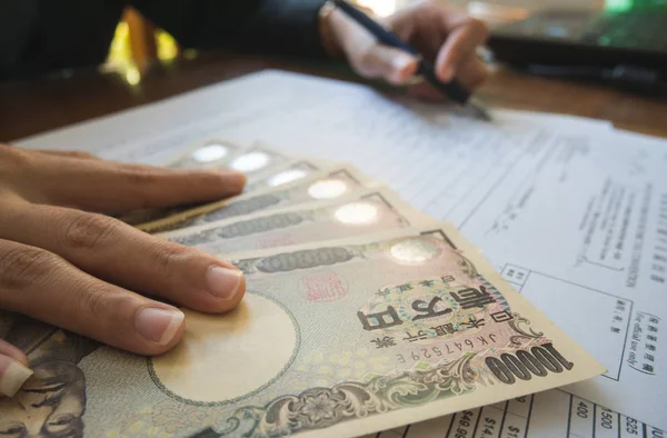 Mulher mão segurar caneta preencher os detalhes sobre os formulários de impostos papel w — Fotografia de Stock