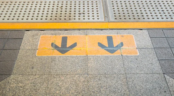 Arrow sign on Railway platform at train station — Stock Photo, Image