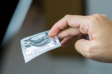 Kadının bulanık arkaplanı güvenli seks konseptinde prezervatif veriyor