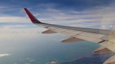 Uçak bir manzara. Uçak bulutların arasından uçuyor.