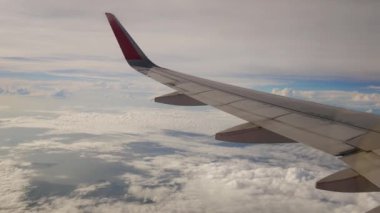 Uçak bir manzara. Uçak bulutların arasından uçuyor.
