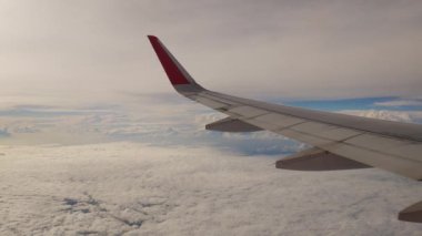 Uçak bir manzara. Uçak bulutların arasından uçuyor.