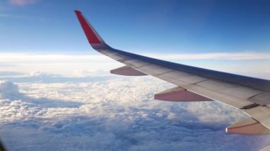 Uçak bir manzara. Uçak bulutların arasından uçuyor.