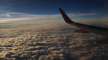 Uçak bir manzara. Uçak bulutların arasından uçuyor.