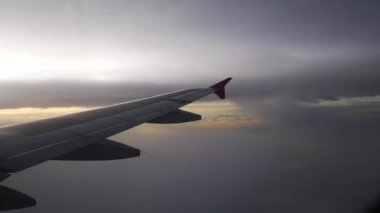 Uçak bir manzara. Uçak bulutların arasından uçuyor.