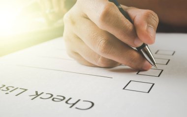 Kapat-vintage tarzı kalem tablet ile onay listesi kağıt üzerinde tutan el kadar