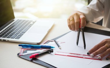 Dişi mimarlar planlarda fikir belirlemek için ayırıcı ve araçlar kullanıyorlar. 