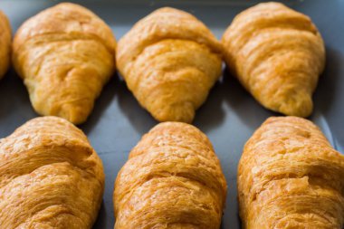 Kahvaltıda servis edilen müşteriler için kruvasanlar ocaktan çıktıktan sonra tepside.