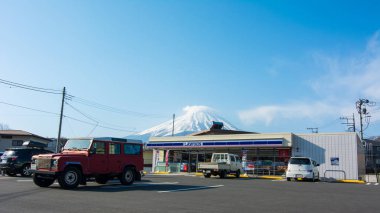 Japonya Nisan 16,2017: Lawson, Japonya Açık 24 saat açık bir mağaza zinciri. Bu şube Kawaguchi Dağı yakınlarında yer almaktadır. Arka planda Fuji ve dükkanın önüne park etmiş kırmızı bir cip.