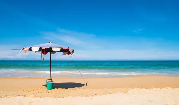 旅行や休日のコンセプトで夏の季節に青い空と美しいビーチでのビーチ傘と氷のバケツ — ストック写真