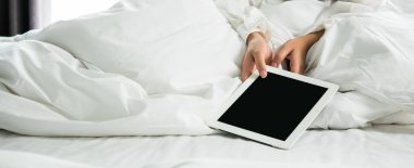 Kapat Asyalı kadın hafta sonu uyandıktan sonra yatağın üzerinde bir tablet kullan. Tableti haber okumak, film izlemek veya yayın ve haberleşme, sosyal medya kavramı ile sohbet etmek için kullan.