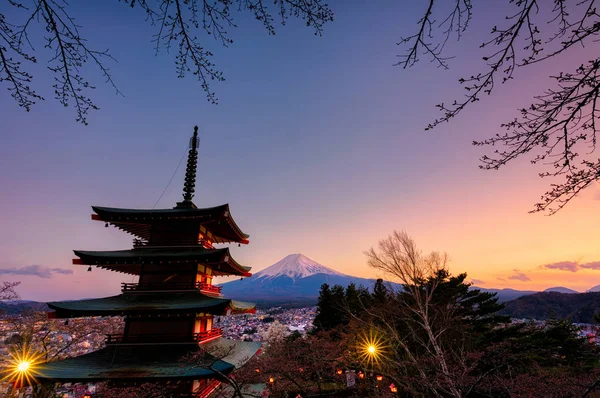 Chureito Pagoda alacakaranlıkta Fuji dağı ve sakura ağacı çerçevesiyle gün batımında.