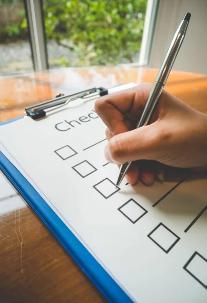 Yakın çekimde, kontrol listesi kağıdına kalem konması ve iş konsepti, klasik tarzı ve softtone biçiminde bilgi doldurma biçimi