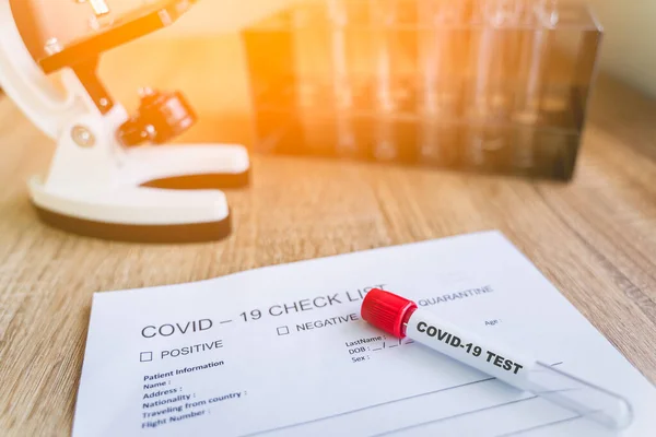 Laboratuvardaki korona virüsünü tespit etmek için COVID19 Kontrol Listesi ve kan testi tüpü. Korona virüsü salgını, salgın hastalıkları veya bulaşıcı kavramları önlemek için aşı bulmak amacıyla araştırılmaktadır.