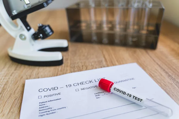 Laboratuvardaki korona virüsünü tespit etmek için COVID19 Kontrol Listesi ve kan testi tüpü. Korona virüsü salgını, salgın hastalıkları veya bulaşıcı kavramları önlemek için aşı bulmak amacıyla araştırılmaktadır.