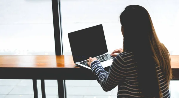 Blogger, Asian Women's writers are using laptops at the coffee shop to write, share stories or travel reviews to her social media followers in travel concept , Soft focus with copy space