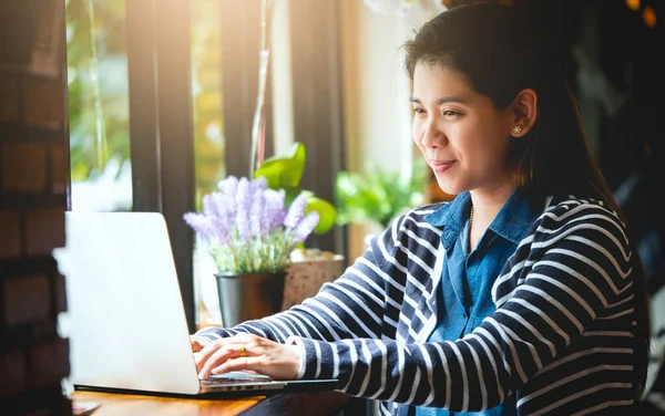 Blogger, Asian Women\'s writers are using laptops at the coffee shop to write, share stories or travel reviews to her social media followers in travel concept , vintage style and Soft focus